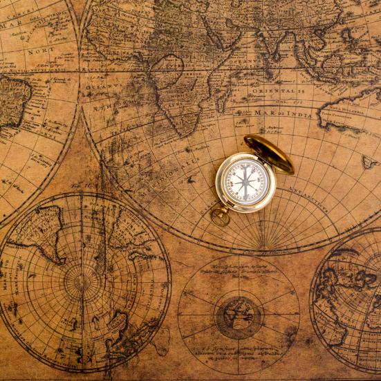 Gammelt verdenskort med et kompas liggende ovenpå.