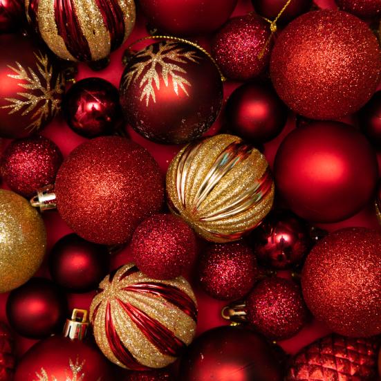 Røde og guldfarvede julekugler med glimmer.