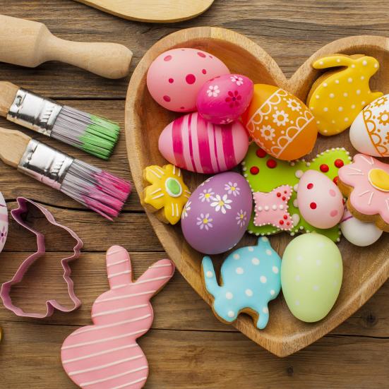 Farverig påskekrea med æg, kaniner, maling og småkager.