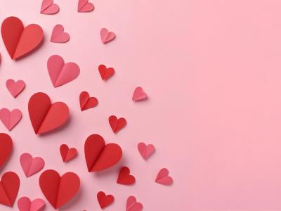 Lyserød baggrund med røde papirhjerter.