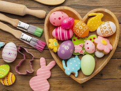 Farverig påskekrea med æg, kaniner, maling og småkager.