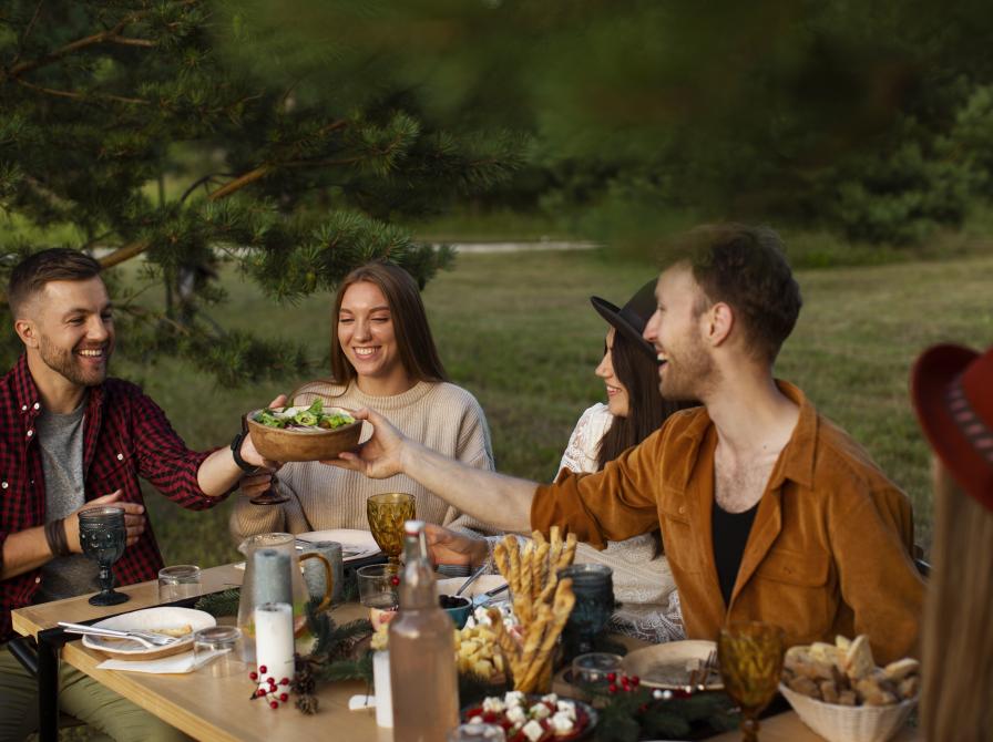 En lille gruppe mennesker, der spiser sammen i det fri.