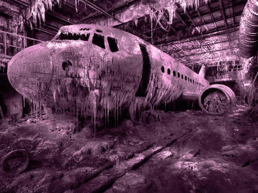 Billedkunst af Michael René Kristiansson, der forestiller et fly i forfald. Billedet er tonet lilla.